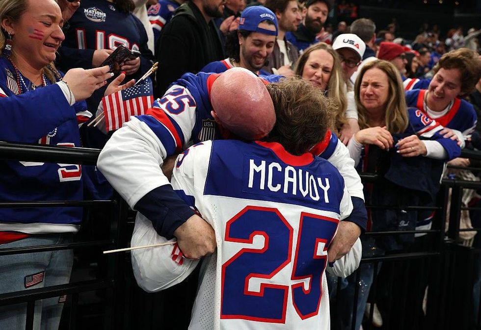 MILAN, ITALY - FEBRUARY 22: Gold medalist Charlie McAvoy #25 of Team United States celebrates with a fan following the Men