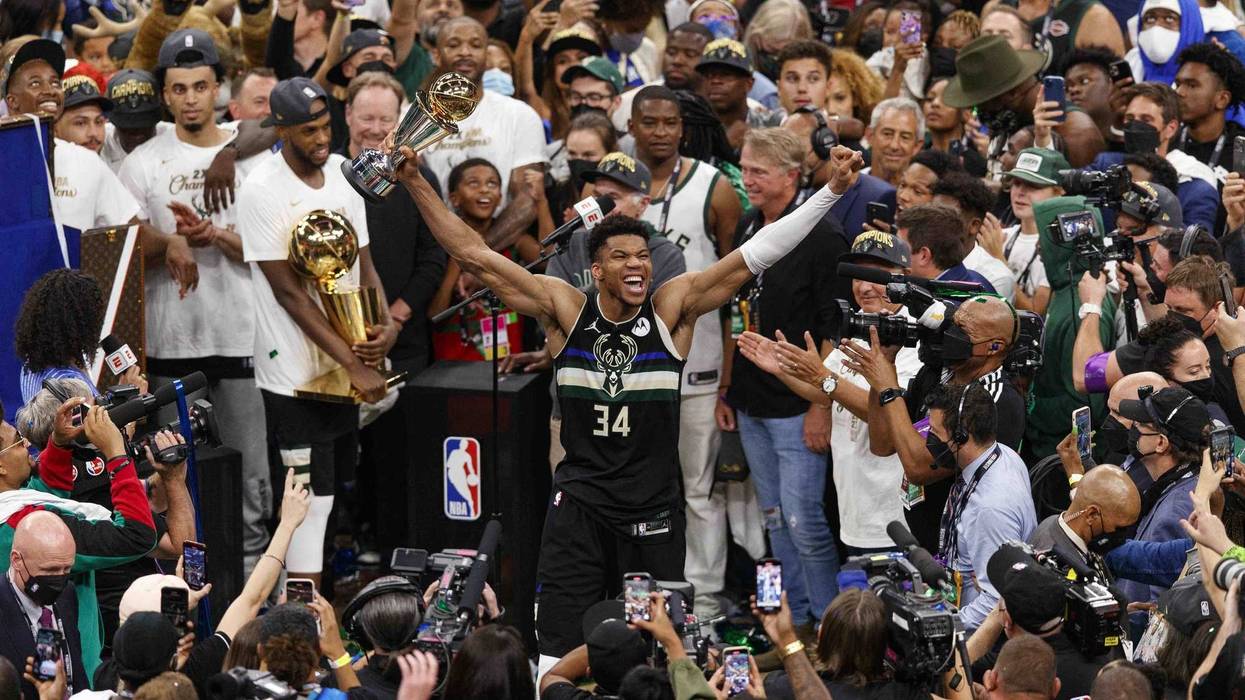 Milwaukee Bucks forward Giannis Antetokounmpo (34) celebrates with the NBA Finals MVP Trophy following the game against the Phoenix Suns following game six of the 2021 NBA Finals at Fiserv Forum.