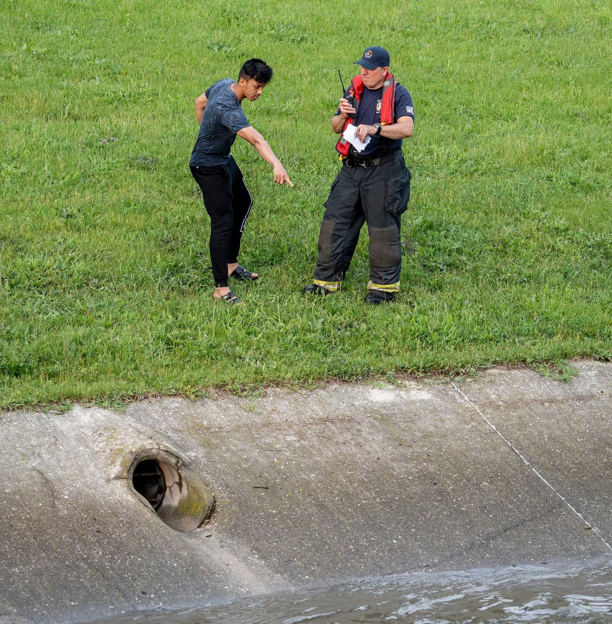 Milwaukee Fire Department personnel speak with a witness who saw an unknown number of people fall into the water at South 27th Street and West Loomis Road in Milwaukee on Monday. Mjs 220613 Rescue P2