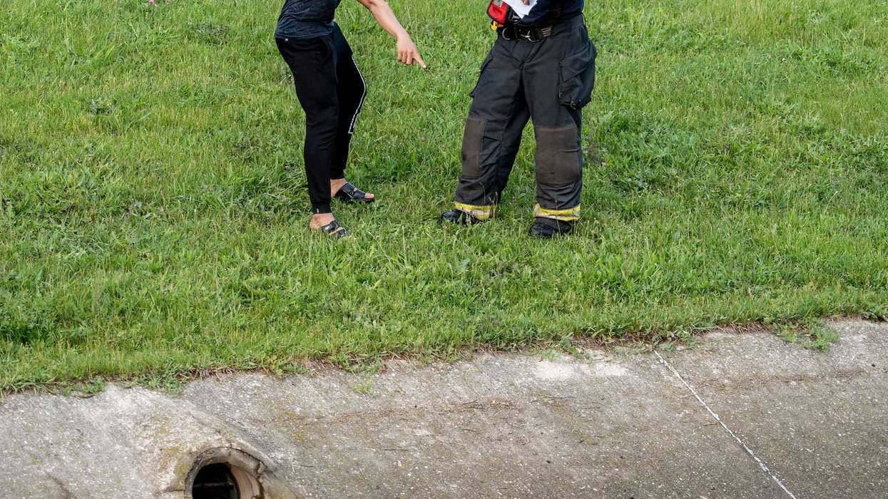 Milwaukee Fire Department personnel speak with a witness who saw an unknown number of people fall into the water at South 27th Street and West Loomis Road in Milwaukee on Monday. Mjs 220613 Rescue P2
