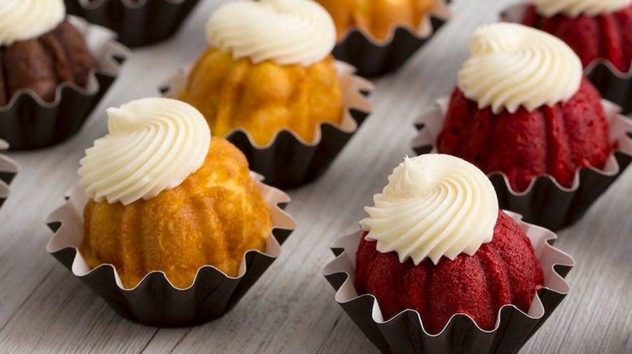Mini bundt cakes with cream cheese icing on a wooden table