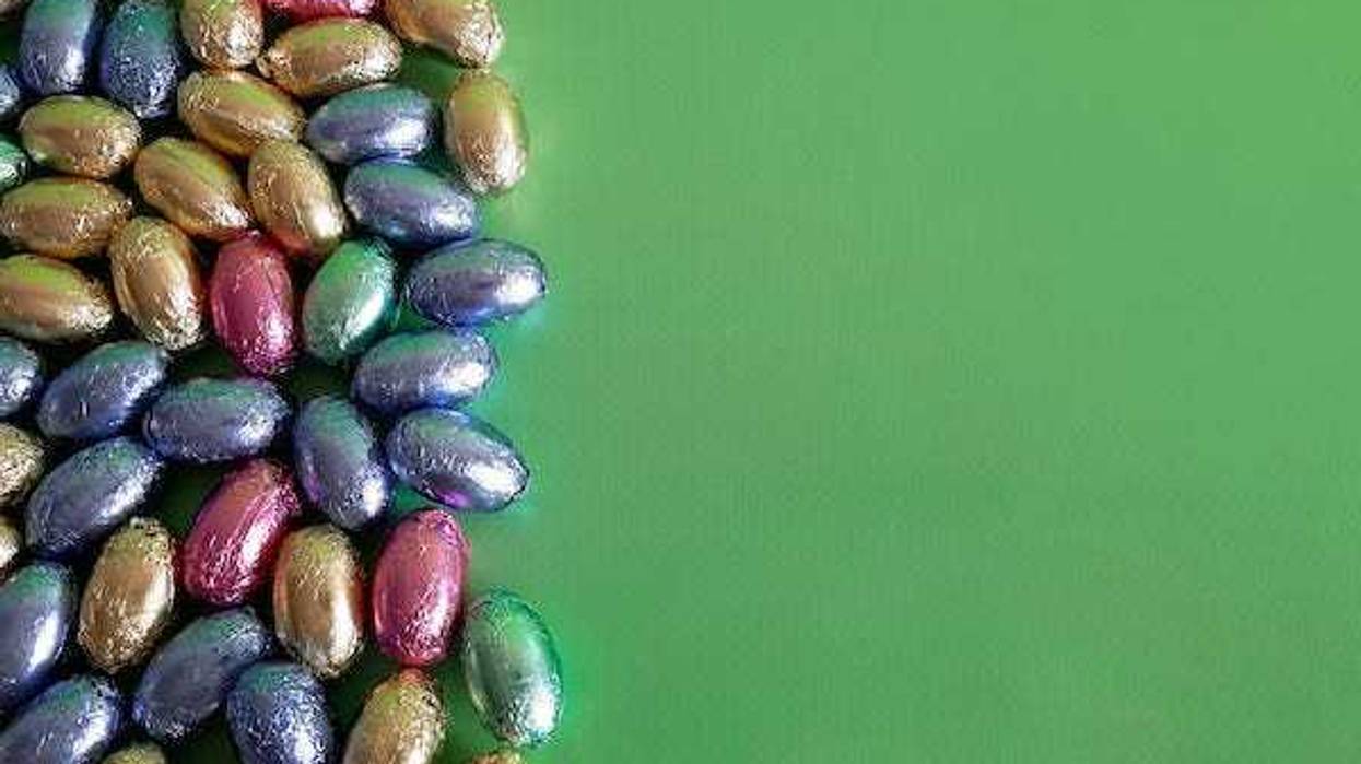 Mini chocolate eggs in front of a green background