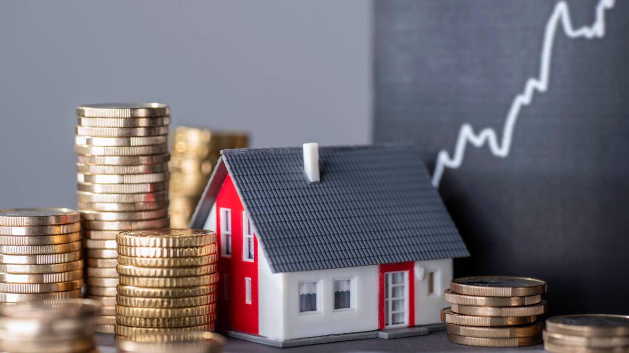miniature home and piles of coins
