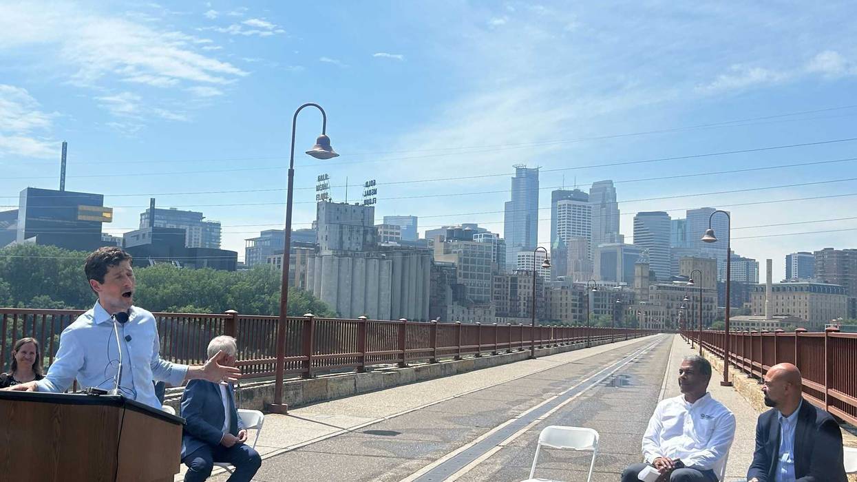 Minneapolis Mayor Jacob Frey (left standing) and Minnesota Governor Tim Walz (left seated) were among the officials announcing the reopening of Minneapolis' famous Stone Arch Bridge on Monday.