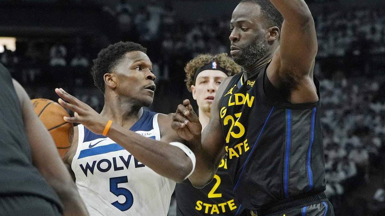 Minnesota Timberwolves guard Anthony Edwards (5) controls the ball against Golden State Warriors forward Draymond Green (23) in the first quarter during game one of the second round for the 2025 NBA Playoffs at Target Center.