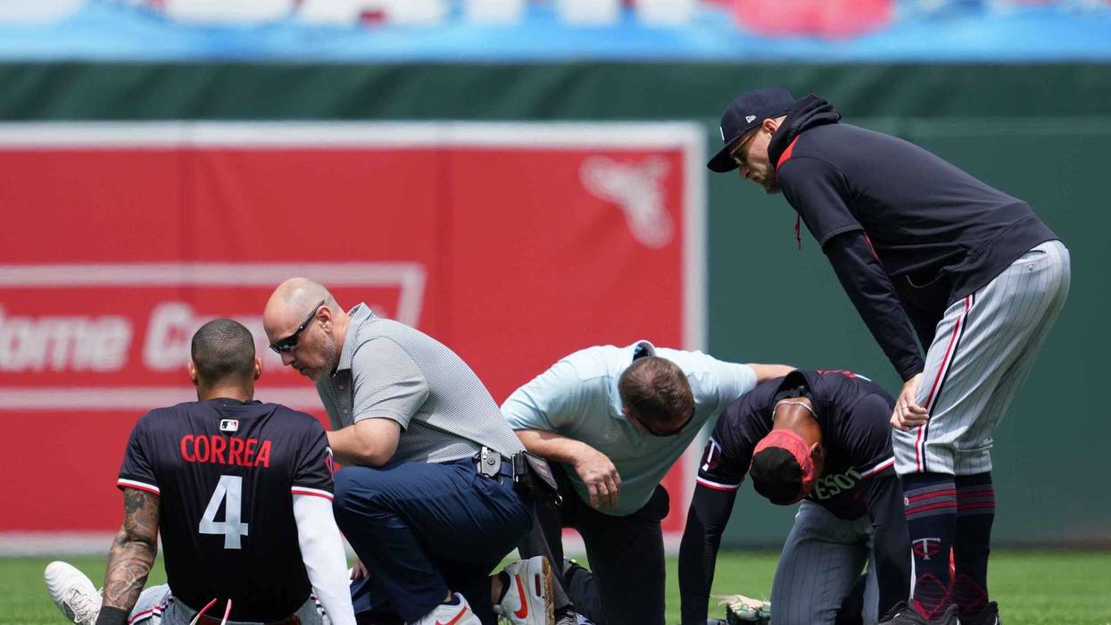 Minnesota Twins outfielder Byron Buxton (25) and shortstop Carlos Correa (4) remain on the ground following a collision while chasing the ball during the third inning against the Baltimore Orioles at Oriole Park at Camden Yards.