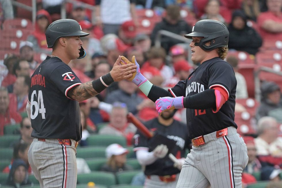 Minnesota Twins outfielder Harrison Bader (12) celebrates with Jose Miranda (64) after hitting a two-run home run during the fifth inning of a baseball game against the St. Louis Cardinals, Thursday, March 27, 2025, in St. Louis