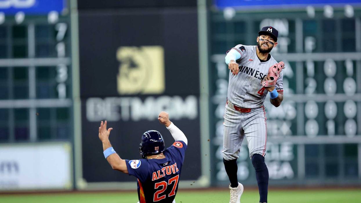 Minnesota Twins shortstop Carlos Correa (4) throws a fielded ball to first base to complete a double play against the Houston Astros during the seventh inning at Daikin Park.