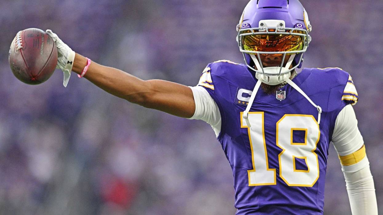 Minnesota Vikings wide receiver Justin Jefferson (18) holds out the ball before the game against the Atlanta Falcons at U.S. Bank Stadium.