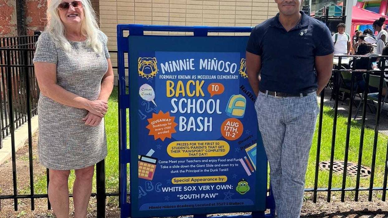 Minnie Miñoso's widow and son standing next to sign