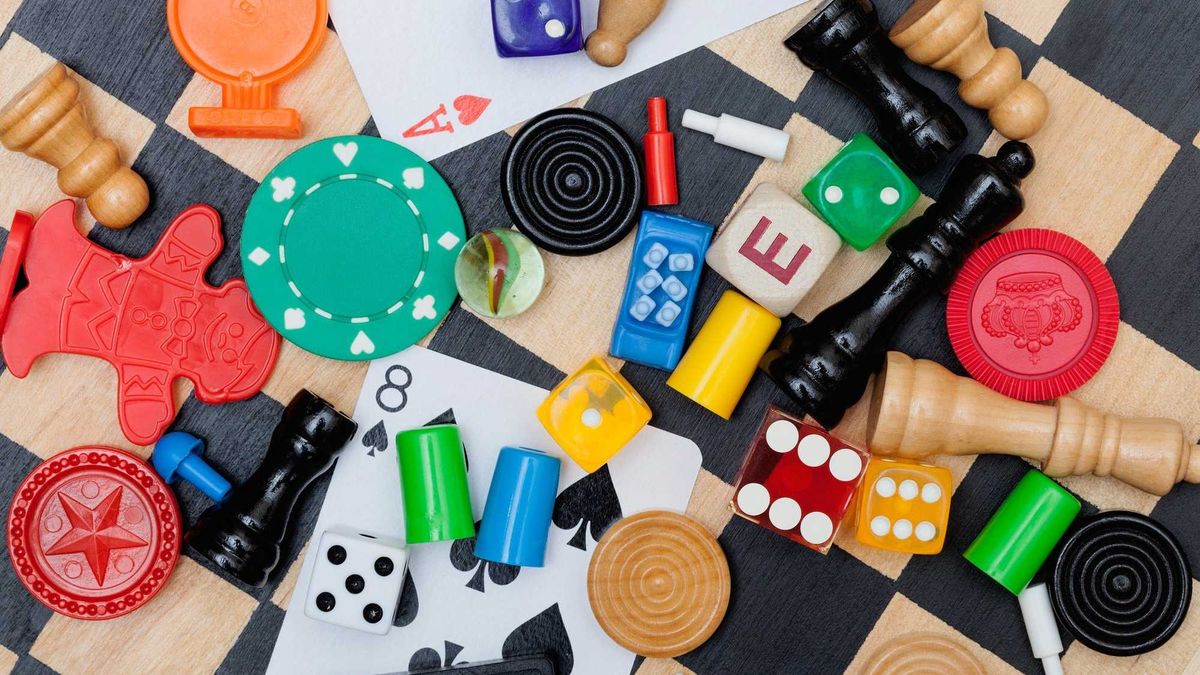 Miscellaneous board game pieces on a chess board - stock photo