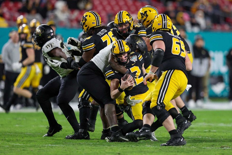 Missouri Tigers quarterback Brady Cook (12) is sacked by Wake Forest Demon Deacons defensive lineman Kobie Turner (0) in the fourth quarter in the 2022 Gasparilla Bowl at Raymond James Stadium.
