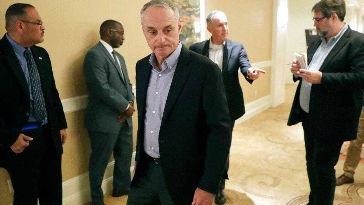 MLB Commissioner Rob Manfred, center, leaves a press conference during MLB baseball owners meetings, Thursday, Feb. 6, 2020, in Orlando, Fla.