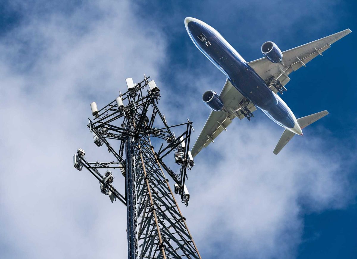 Mobile cellphone tower and an aircraft flying over top.