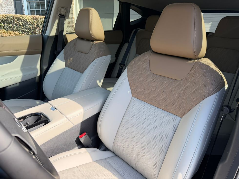 Modern car interior with two-tone tan and beige quilted leather seats and center console.