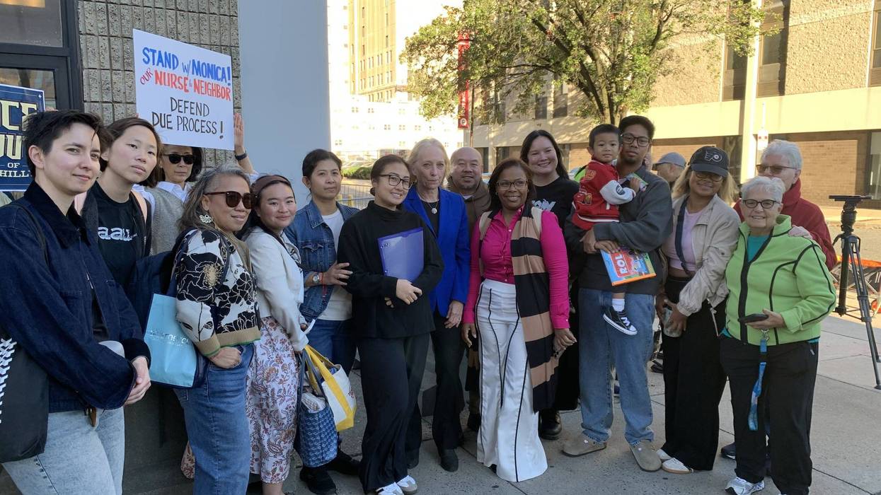 Monica Ryadi (center) poses for a photo with supporters and Rep. Mary Gay Scanlon before a meeting at Philadelphia ICE headquarters about removing her tracking device.