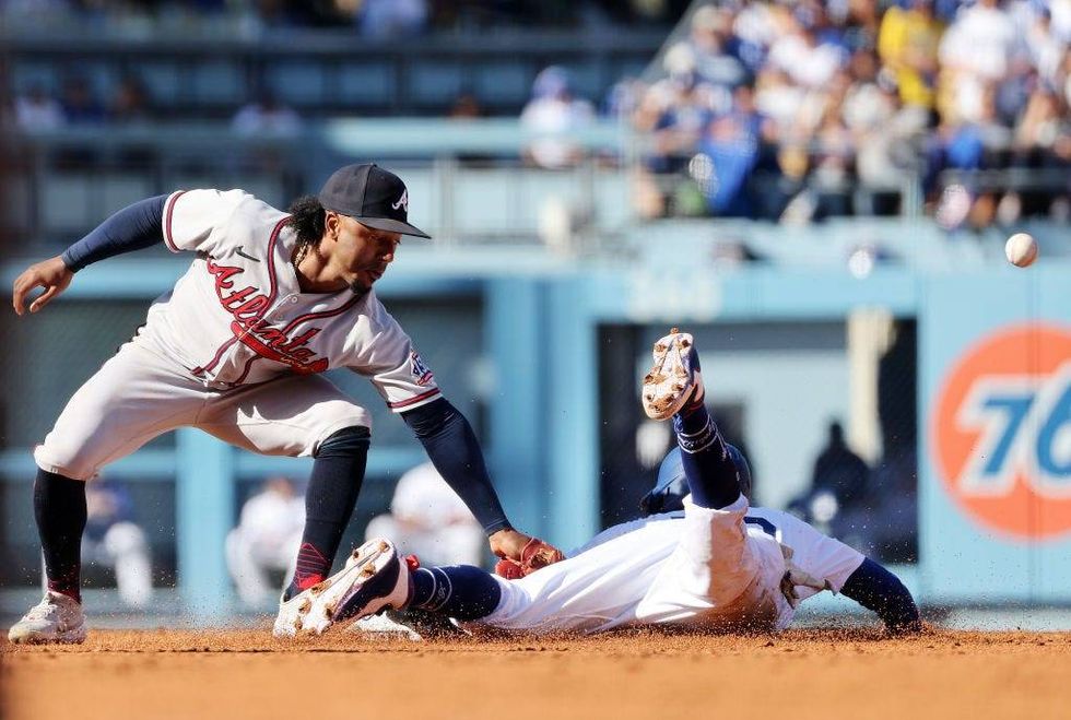 Mookie Betts #50 of the Los Angeles Dodgers steals second base as Ozzie Albies #1 of the Atlanta Braves mishandles the throw during the 2nd inning.