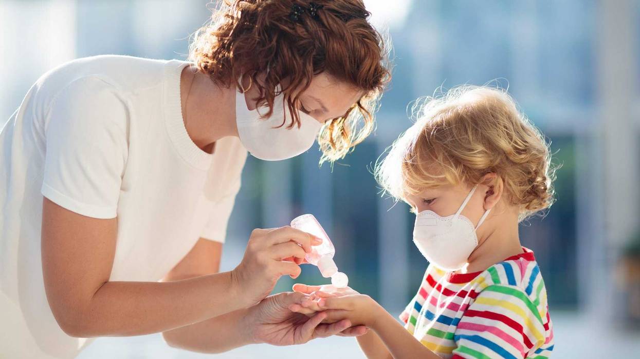 Mother and child with face mask and hand sanitizer