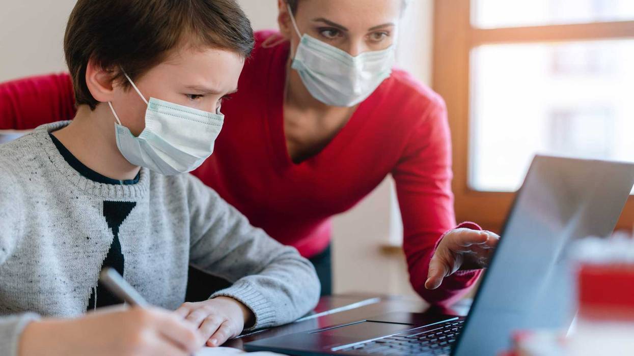 Mother and son in video chat with teacher wearing masks