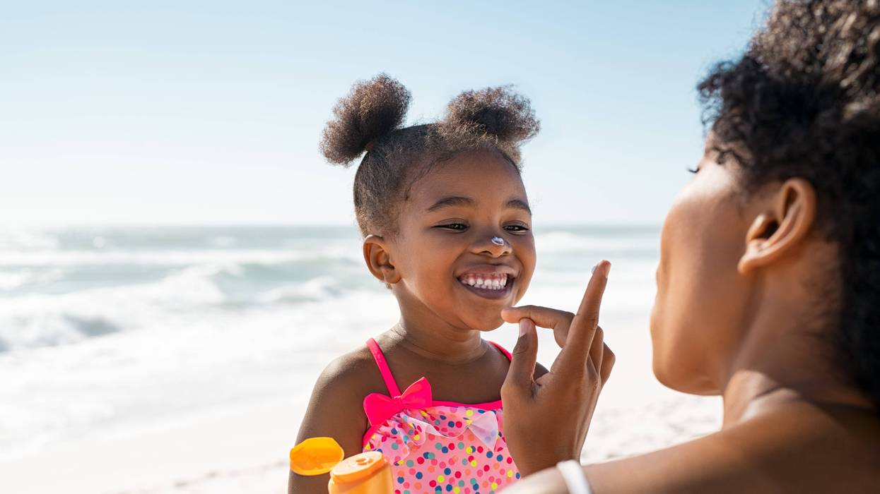 Mother applies sunblock to little girl