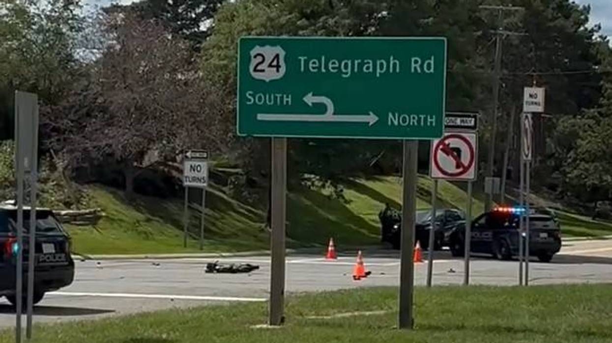 Motorcycle accident on Telegraph Rd with police cars, traffic cones, and debris.