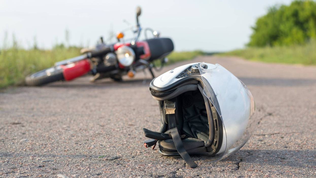 Motorcycle, helmet lying in road