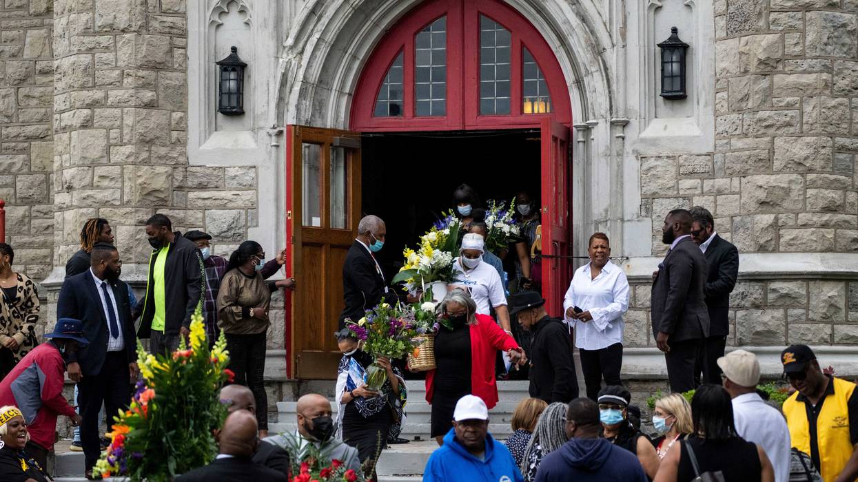 Mourners carry out flowers as people depart from the funeral of Heyward Patterson at Lincoln Memorial United Methodist Church on Friday, May 20, 2022 in Buffalo, NY. The Patterson was one of 10 people who were killed in the mass shooting at Tops Friendly Market at Jefferson Avenue and Riley Street in a historically Black neighborhood of Buffalo by a young white gunman is being investigated as a hate crime and an act of racially motivated violent extremism, according to federal officials.