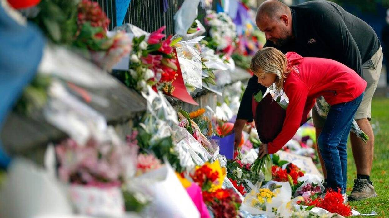 Mourners lay flowers on a wall at the Botanical Gardens in Christchurch, New Zealand, Saturday, March 16, 2019.