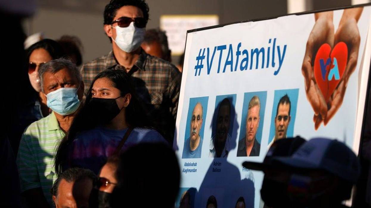 Mourners stand next to a poster with images of the nine Santa Clara Valley Transportation Authority (VTA) light rail yard shooting victims during a vigil at San Jose City Hall on May 27, 2021 in San Jose, California.