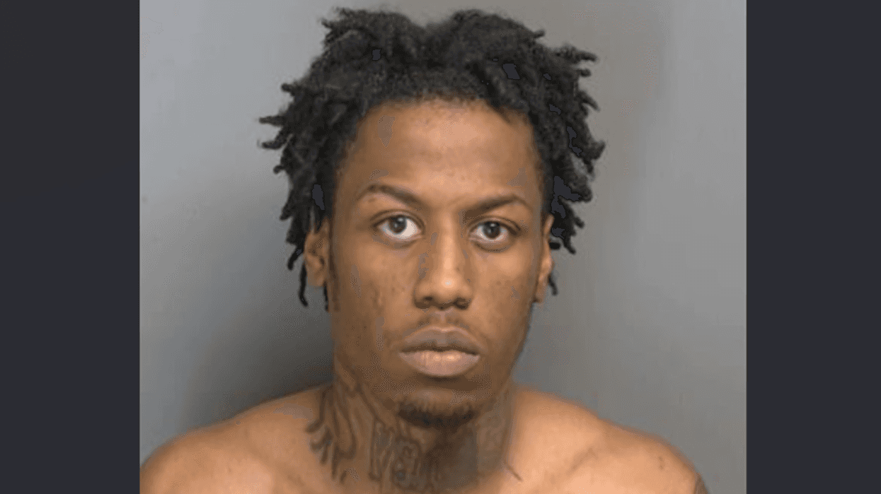 Mugshot of a young Black man with dreadlocks, neck tattoos, and shirtless.