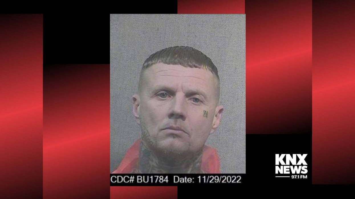 mugshot of white man with tattoos on neck and cheek