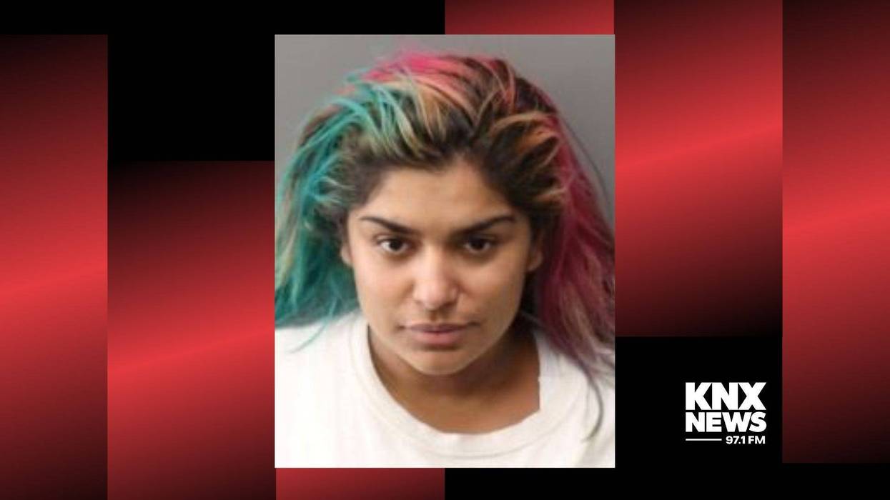mugshot of woman with dyed green and pink hair