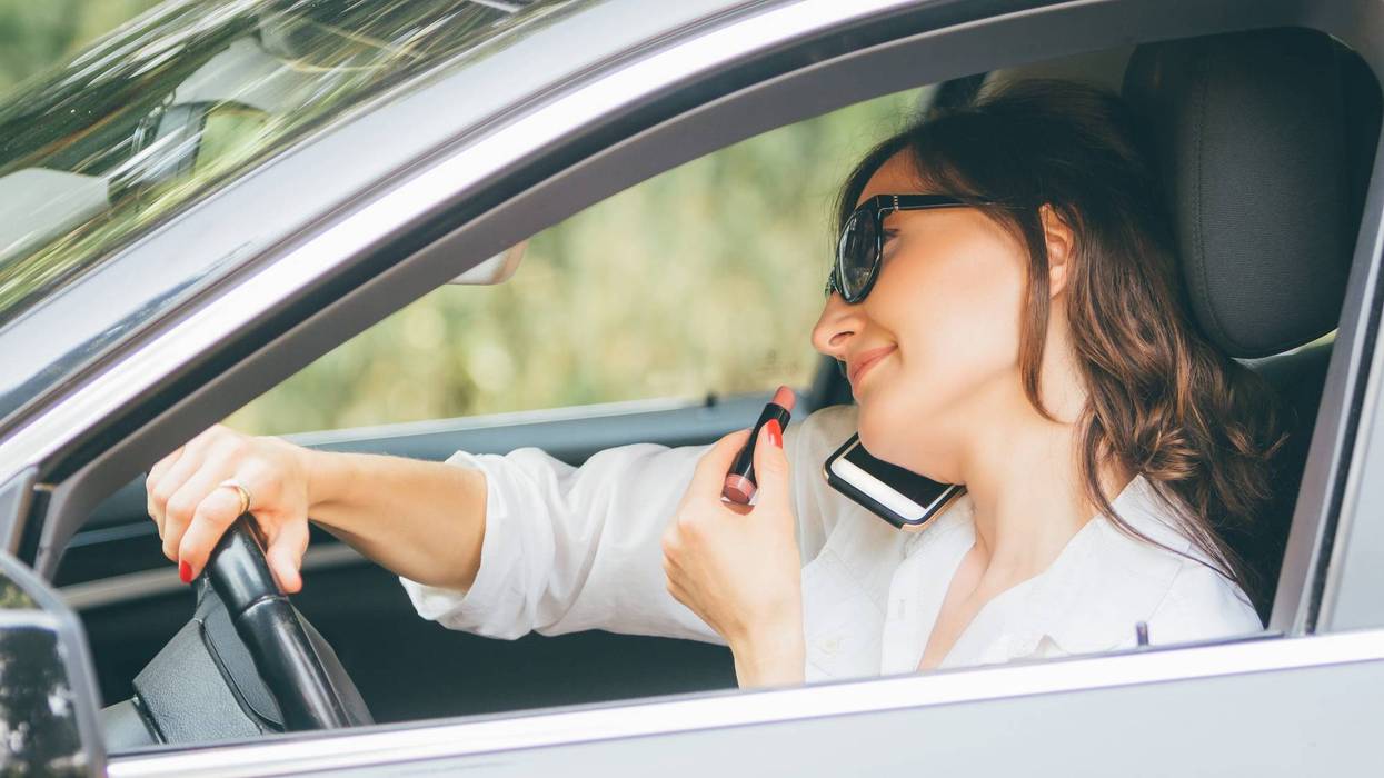 multitasking lady drives with lipstick and smartphone