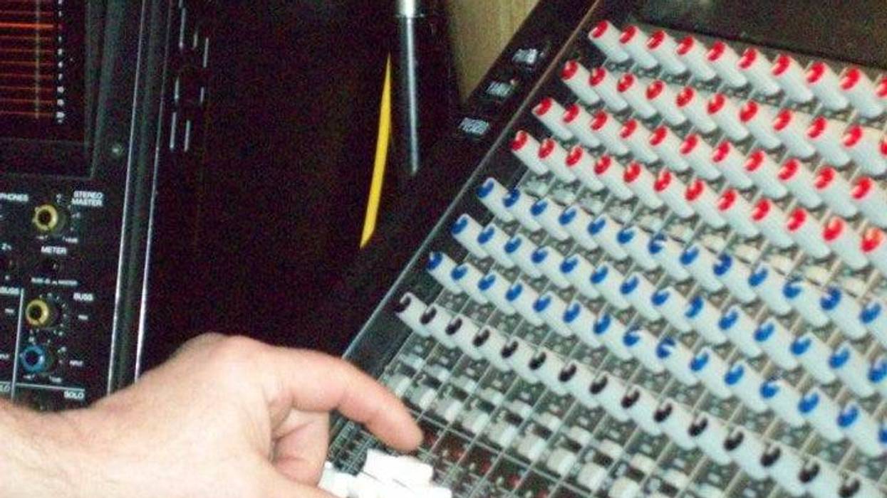 music sound mixing board with hand on lever