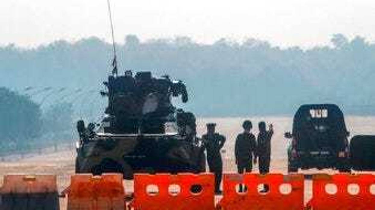Myanmar's military stand guard at a checkpoint manned with an armored vehicle in a road leading to the parliament building Tuesday, Feb. 2, 2021, in Naypyitaw, Myanmar. (AP Photo)