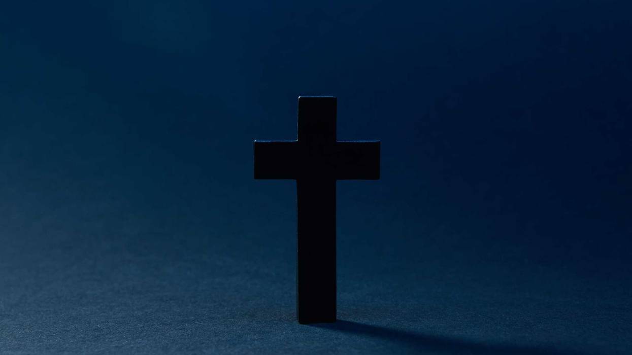 Mysterious classic dark cross isolated on the dark solid fond blue background