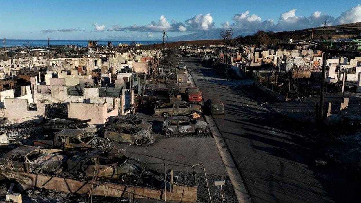 n an aerial view, burned cars and homes are seen in a neighborhood that was destroyed by a wildfire on August 18, 2023 in Lahaina, Hawaii.