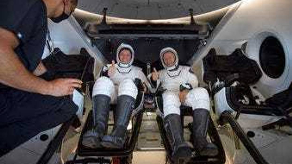 NASA astronauts Robert Behnken, left, and Douglas Hurley are seen inside the SpaceX Crew Dragon Endeavour spacecraft onboard the SpaceX GO Navigator recovery ship. (Bill Ingalls/NASA via AP)