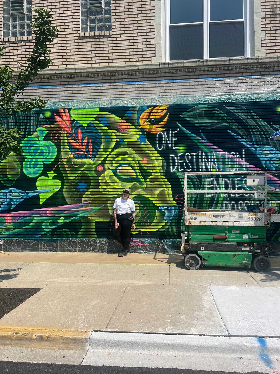 Natalie Shugailo poses in front of her mural in west suburban Forest Park.