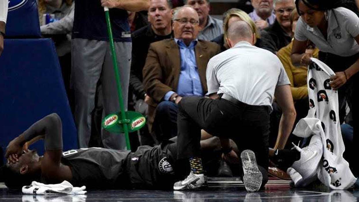 Nets guard Caris LeVert (22) is tended to after an injury during the second quarter of an NBA basketball game against the Minnesota Timberwolves on Nov. 12, 2018, in Minneapolis.