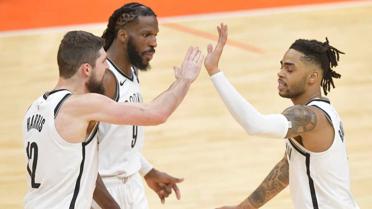 Nets guard D'Angelo Russell (right) celebrates with forward Joe Harris (left) and forward DeMarre Carroll in the third overtime against the Cleveland Cavaliers on Feb. 13, 2019, at Quicken Loans Arena.