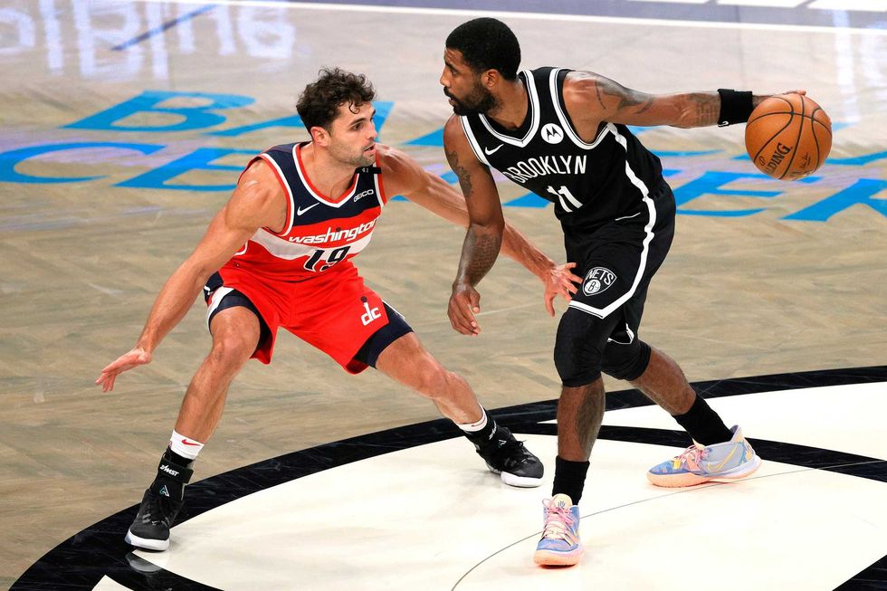 Nets point guard Kyrie Irving surveys the floor in a preseason game against Washington
