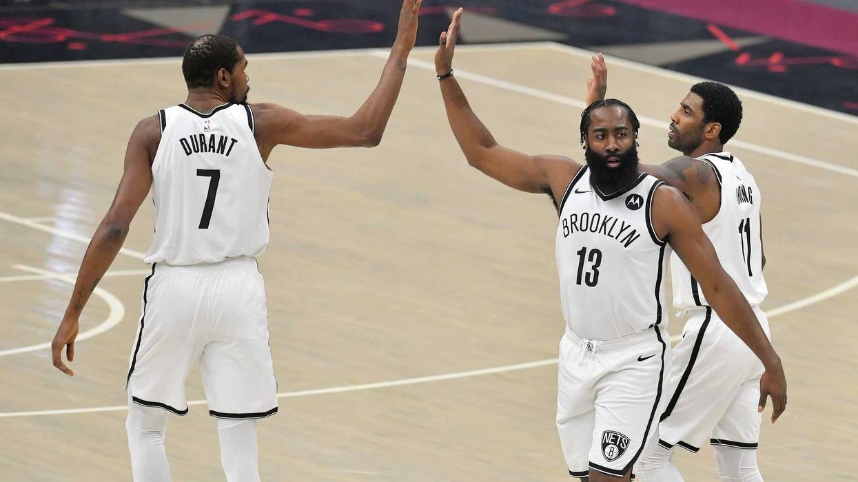 Nets stars Kevin Durant, Kyrie Irving, and James Harden high-five.