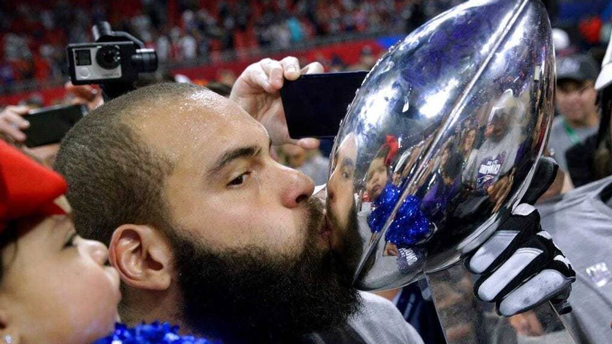 New England Patriots' Lawrence Guy kisses the trophy after the NFL Super Bowl 53 football game against the Los Angeles Rams, Sunday, Feb. 3, 2019, in Atlanta
