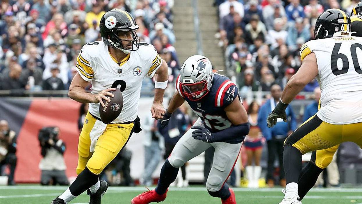 New England Patriots linebacker Christian Elliss chases Pittsburgh Steelers quarterback Aaron Rodgers