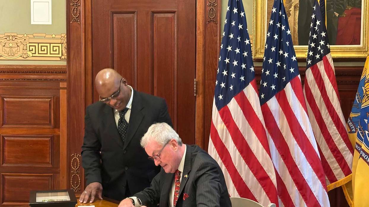 New Jersey Gov. Phil Murphy signs a pardon for Abdur Azam, left, on Monday, Dec. 16, 2024, at his statehouse office in Trenton.