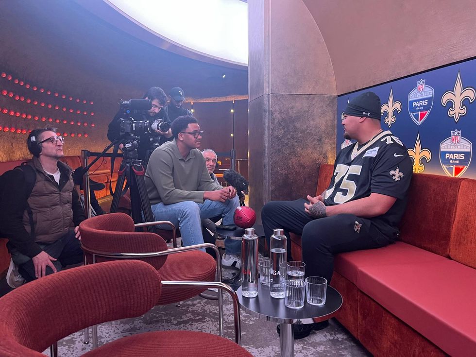 New Orleans Saints player #75 being filmed and interviewed with an NFL Paris Game backdrop.