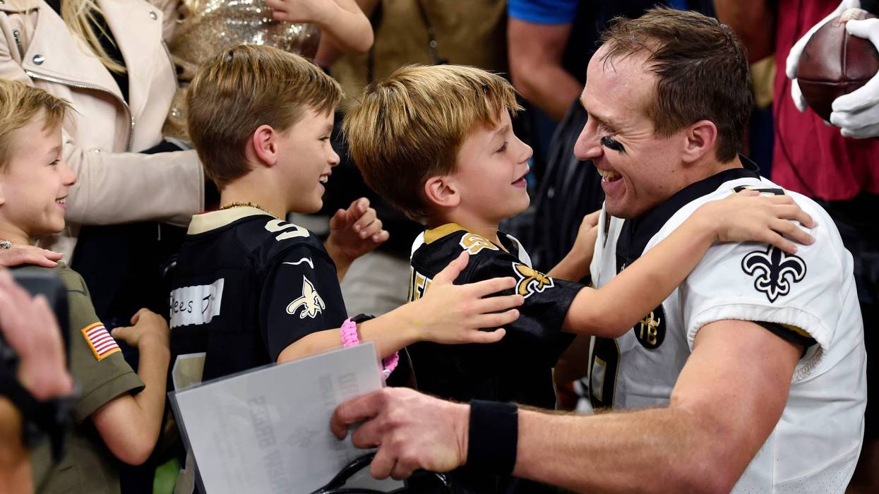 New Orleans Saints quarterback Drew Brees (9) greets his family after breaking the NFL all-time passing yards record in the first half of an NFL football game against the Washington Redskins in New Orleans, Monday, Oct. 8, 2018.
