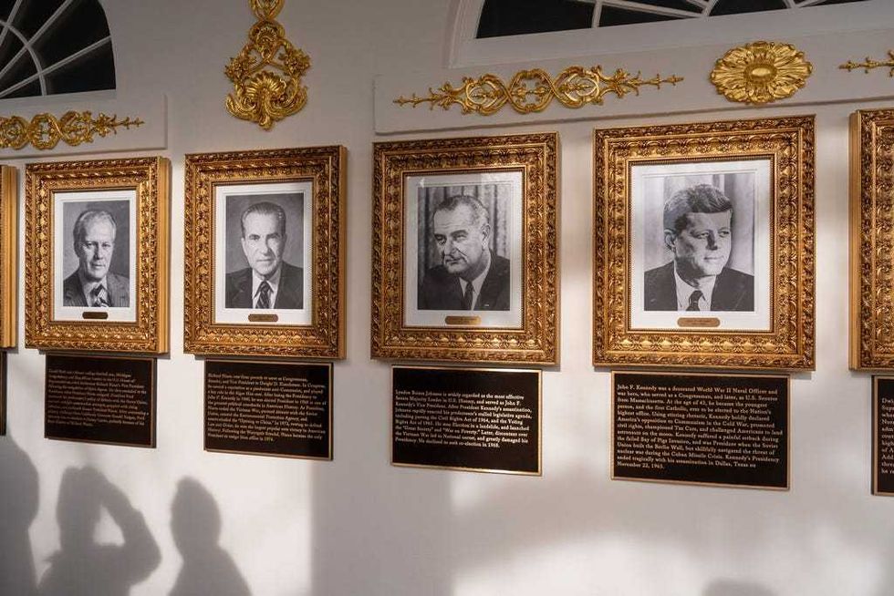 New plaques of explanatory text are seen beneath a framed portrait in the space for former President Joe Biden on the Presidential Walk of Fame on the Colonnade of the White House, Wednesday, Dec. 17, 2025, in Washington.