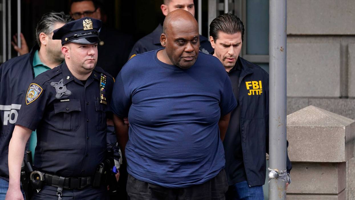 New York City Police and law enforcement officials lead subway shooting suspect Frank R. James, 62, center, away from a police station, in New York, Wednesday, April 13, 2022